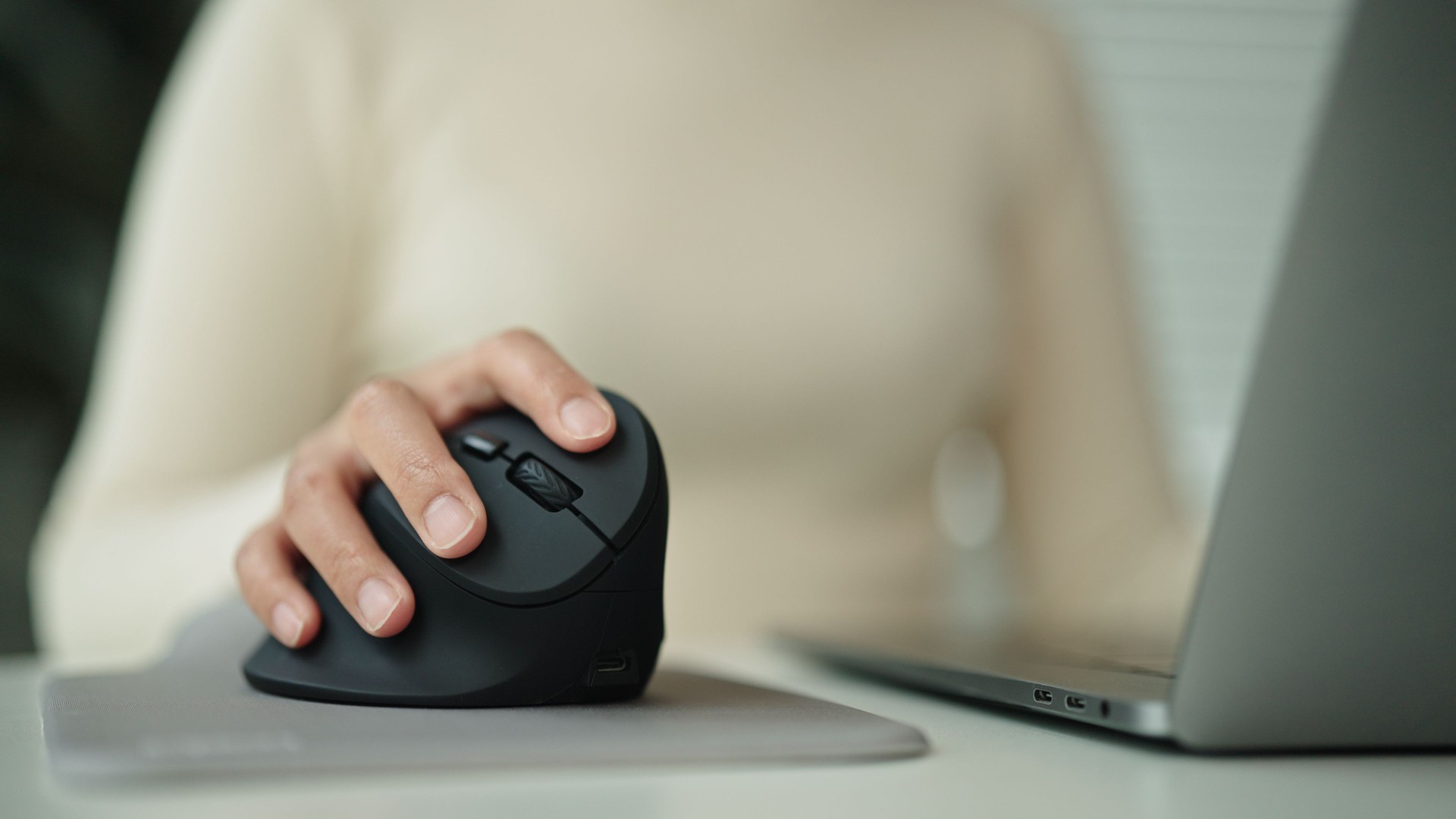 Woman using computer mouse while working.